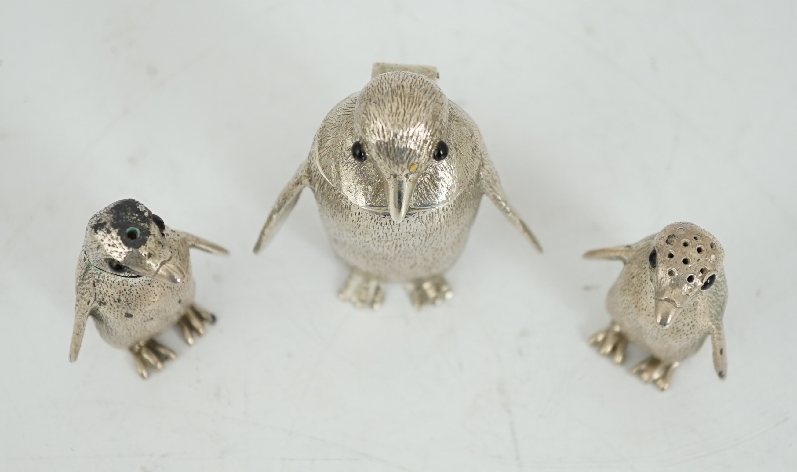 An Elizabeth II graduated suite of three novelty silver condiments, modelled as penguins, by William Comyns & Sons Ltd